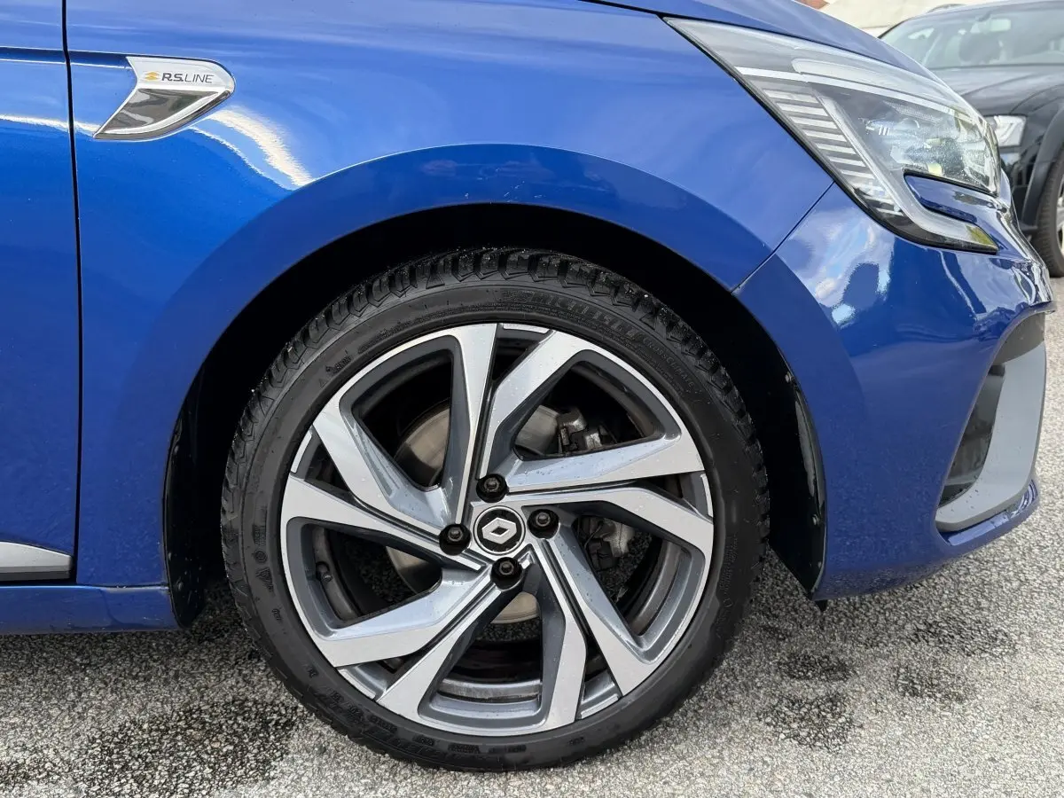 Gros plan sur la roue avant gauche d’une Renault Clio RS Line bleu 2021 avec logo RS Line sur l’aile.