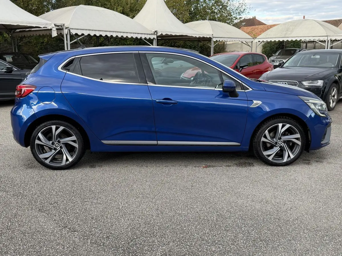 Renault Clio RS Line bleu vue de profil côté gauche, jantes alliage et vitres teintées visibles.