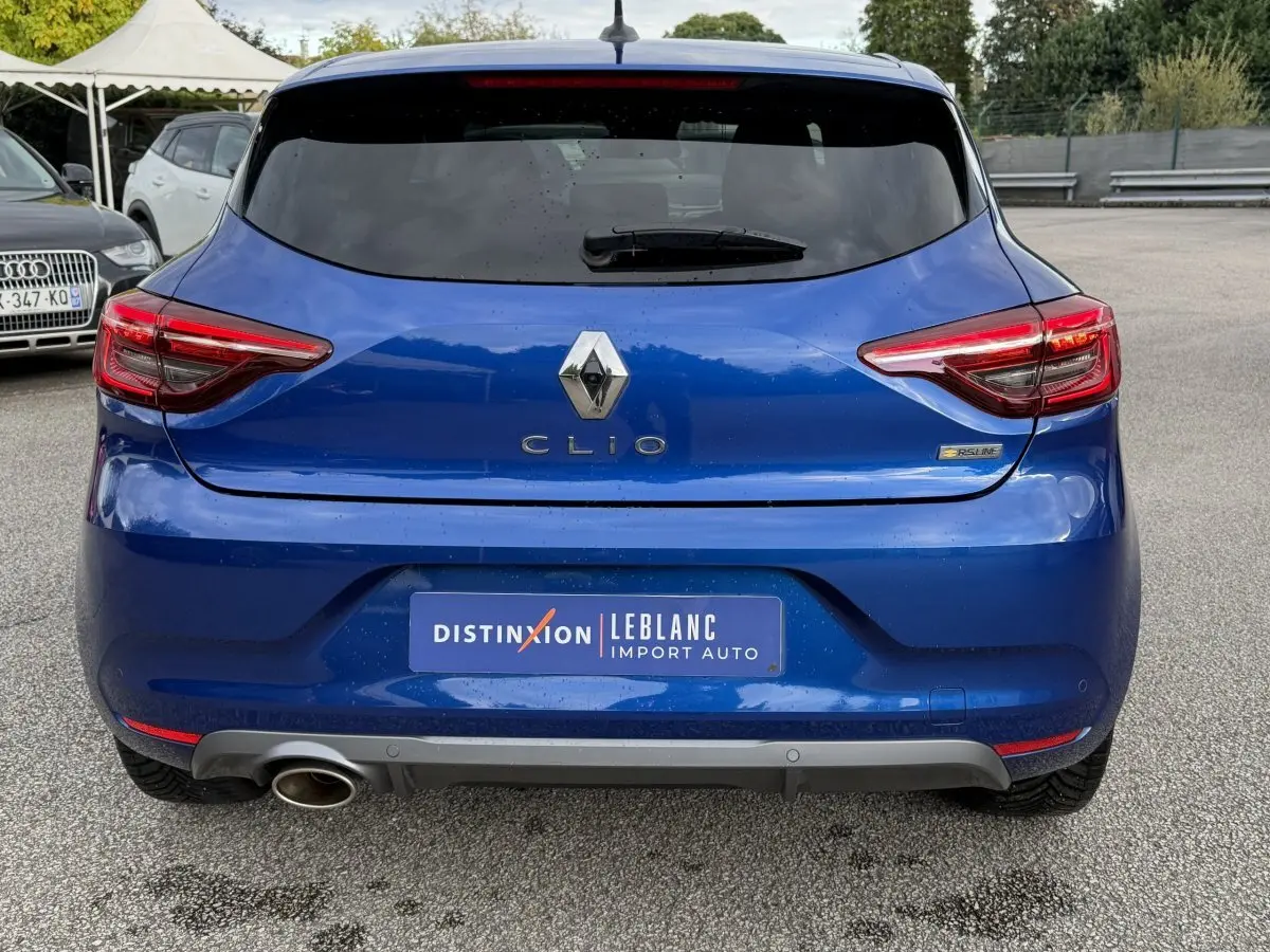 Vue arrière d'une Renault Clio RS Line bleu, avec feux LED et sortie d'échappement visible côté gauche.