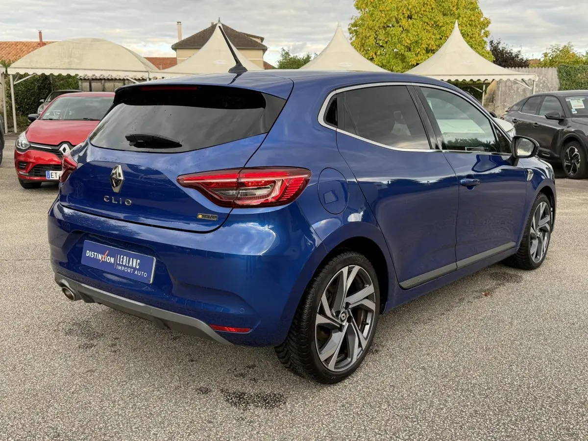 Renault Clio RS Line bleu vue 3/4 arrière droit, jantes alliage et feux arrière LED distinctifs.