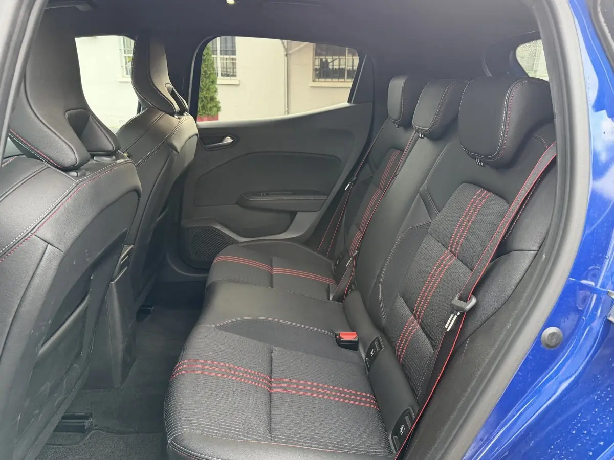 Vue intérieure côté droit sur la banquette arrière noire avec surpiqûres rouges de la Renault Clio RS Line bleu 2021.