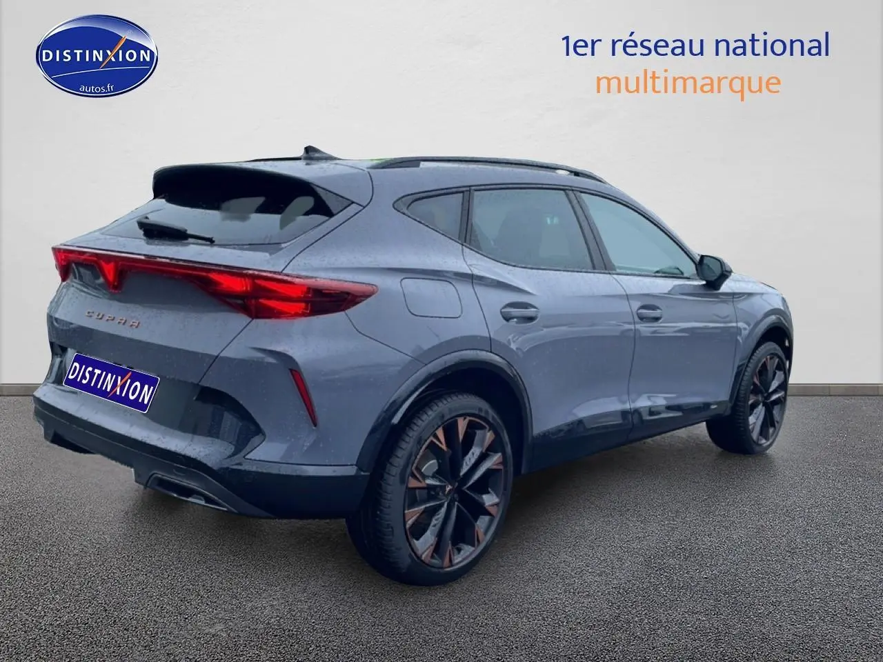 Vue 3/4 arrière droite du CUPRA Formentor gris graphene avec jantes 19 pouces et feux arrière LED allumés.