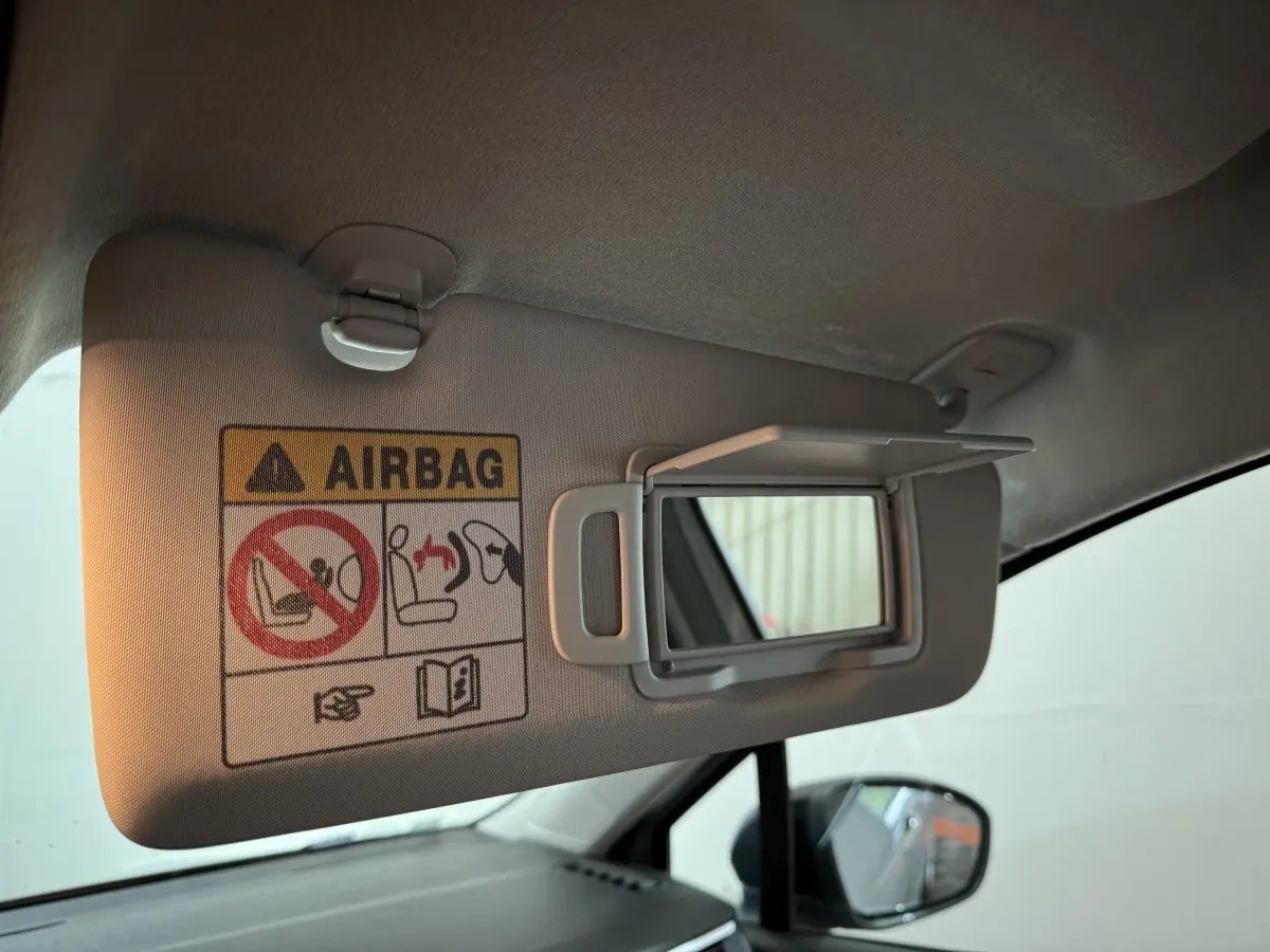 Détail du pare-soleil côté conducteur avec miroir et avertissement airbag dans une Renault Clio gris clair.
