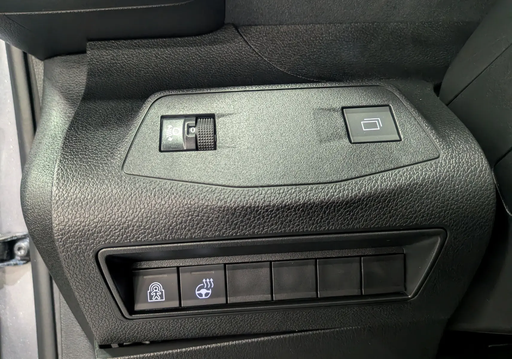 Gros plan sur les commandes noires du tableau de bord côté conducteur du Peugeot Rifter gris acier 2025.