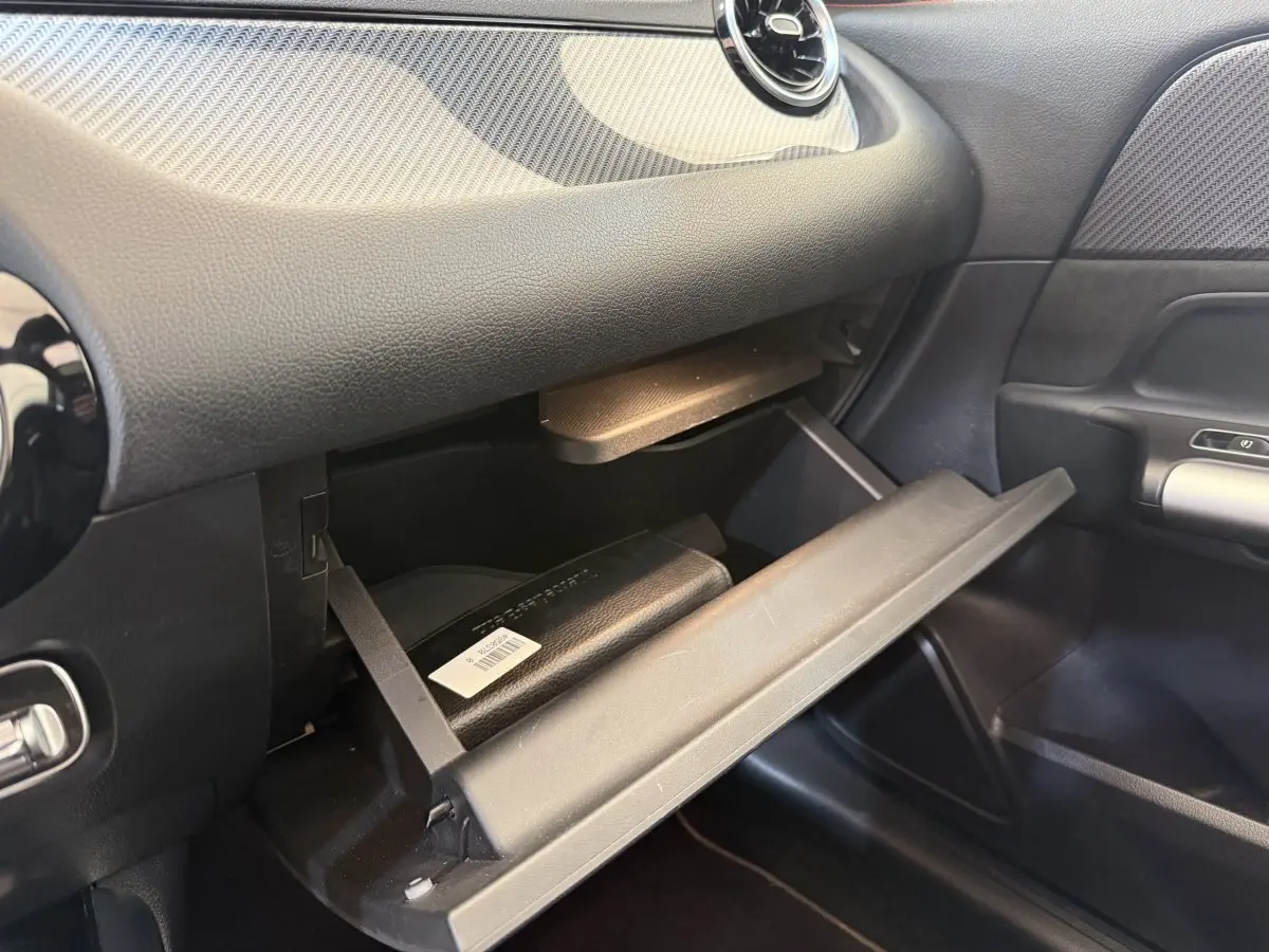 Gros plan sur la boîte à gants ouverte côté passager du Mercedes GLA 250 e AMG Line gris clair 2023.