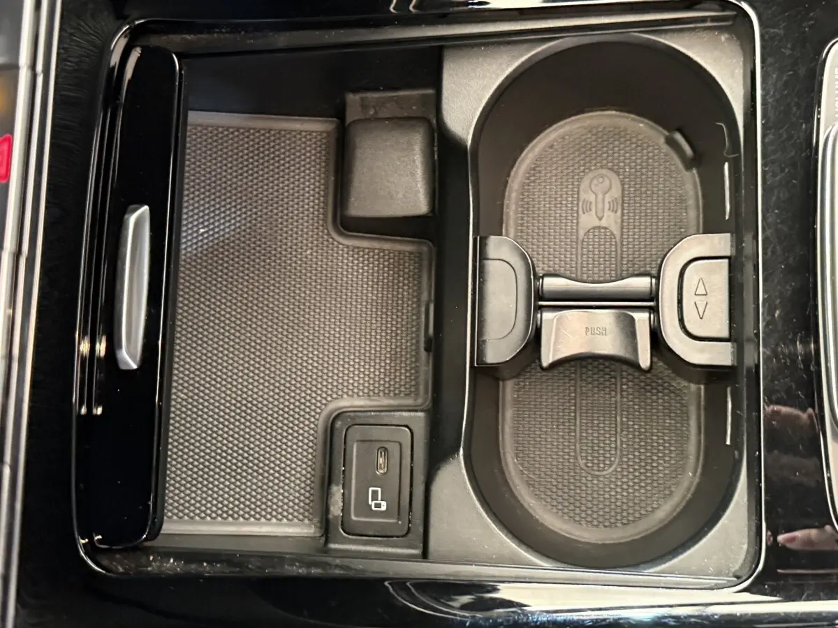 Vue rapprochée de la console centrale noire du Mercedes GLA 250 e AMG Line avec porte-gobelets et port USB-C.
