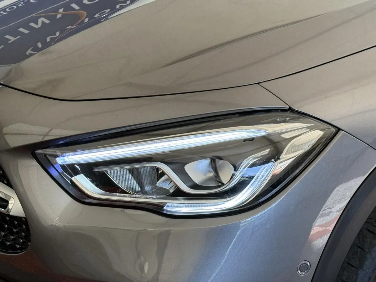 Gros plan sur le phare avant droit LED d’un Mercedes GLA 250 e AMG Line gris clair, soulignant ses lignes modernes.
