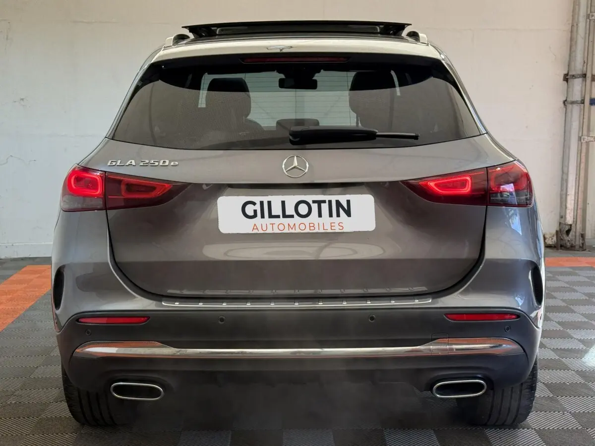 Vue arrière d'un Mercedes GLA 250 e AMG Line gris clair avec feux LED et double sortie d'échappement chromée.