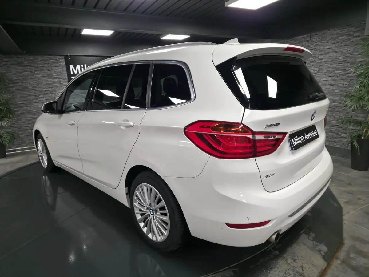 BMW Série 2 Gran Tourer blanc vue 3/4 arrière droit, avec jantes alliage et badge xDrive visible sur le hayon.