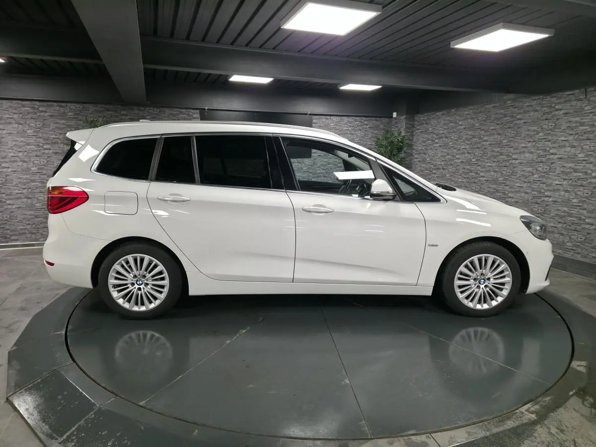 Vue latérale droite d'une BMW Série 2 Gran Tourer blanche avec jantes alliage 17'' et vitres teintées.