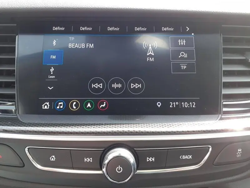 Écran tactile central de l’Opel Insignia Grand Sport 2021 affichant la radio FM, avec commandes physiques en dessous.