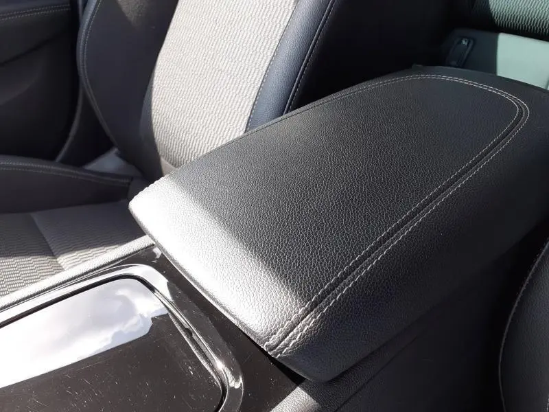 Gros plan sur l'accoudoir central en cuir noir avec surpiqûres blanches de l'Opel Insignia Grand Sport 2021.