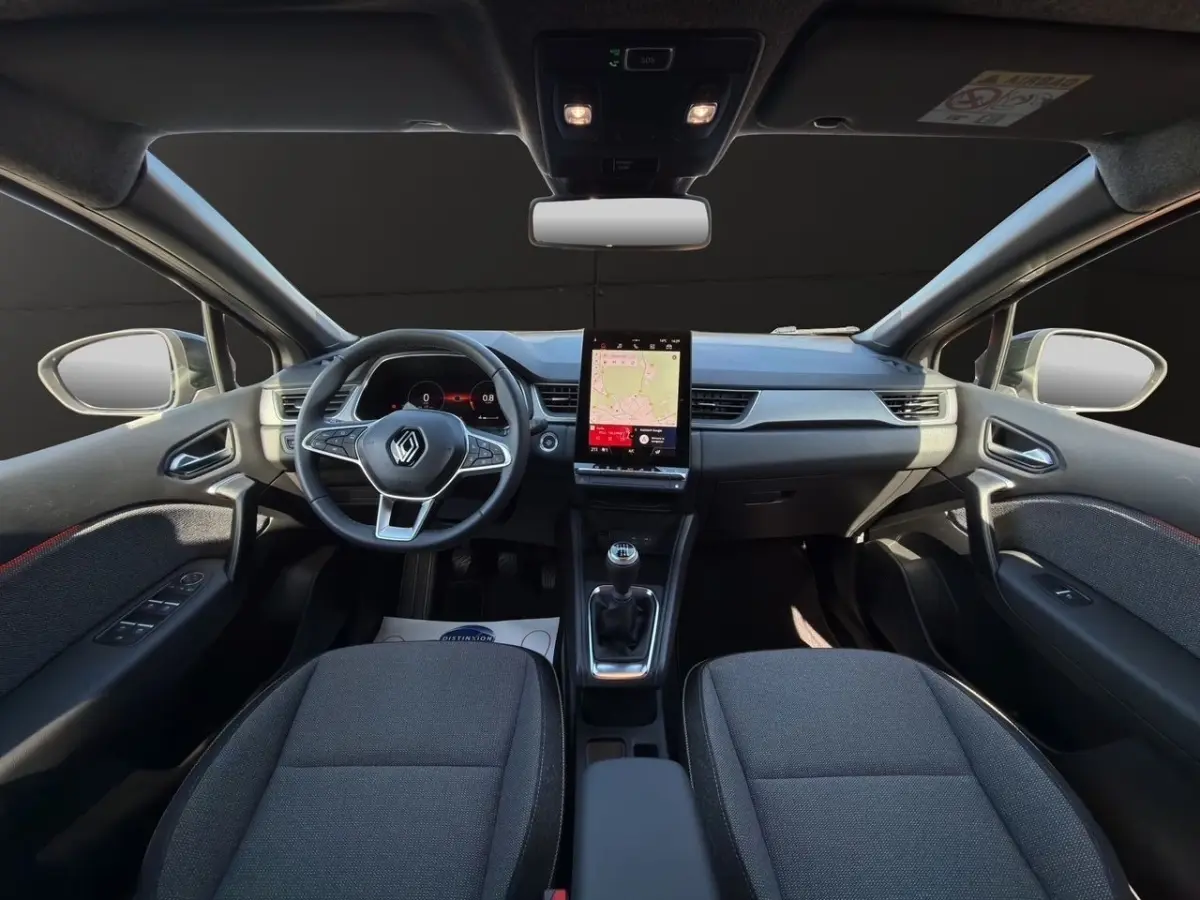 Vue intérieure avant du Renault Captur Techno TCe 90 2024, tableau de bord gris avec écran tactile vertical et volant multifonctions.
