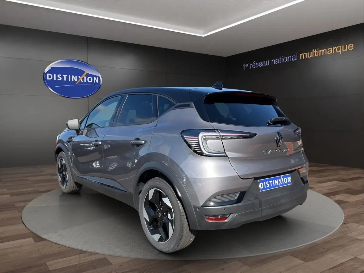Vue 3/4 arrière droite d'un Renault Captur Techno gris foncé avec toit noir et feux arrière LED distinctifs.