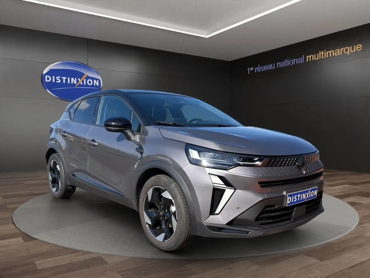 Renault Captur Techno TCe 90 gris foncé en 3/4 avant droit, avec phares LED et jantes noires distinctives.