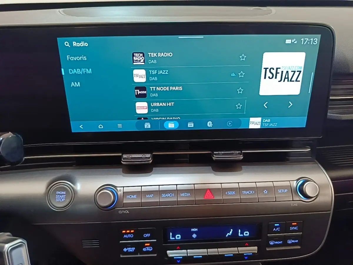 Vue rapprochée de l’écran tactile central et des commandes du tableau de bord du Hyundai Kona 1.6 Hybrid vert 2024.