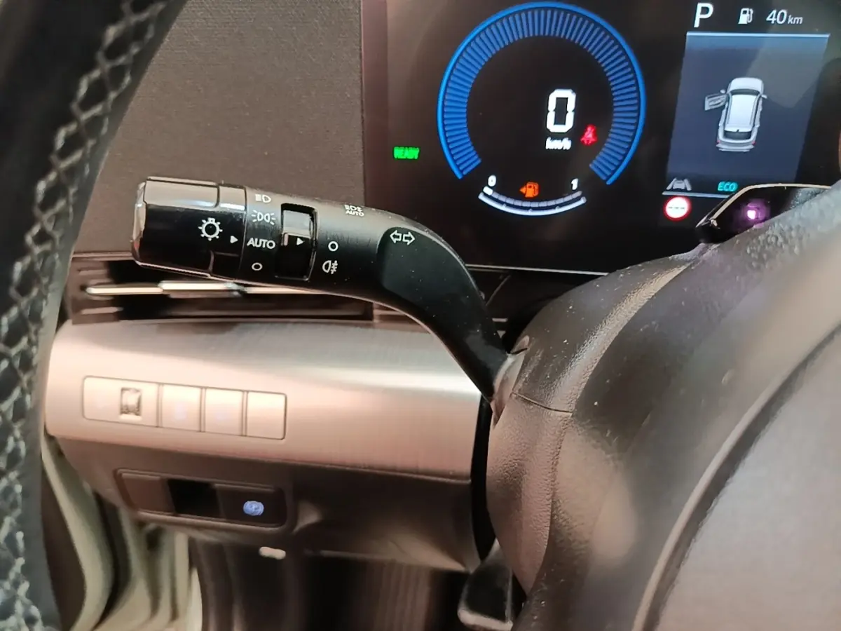 Gros plan sur la manette de clignotants et tableau de bord numérique du Hyundai Kona 1.6 Hybrid 2024, intérieur noir.