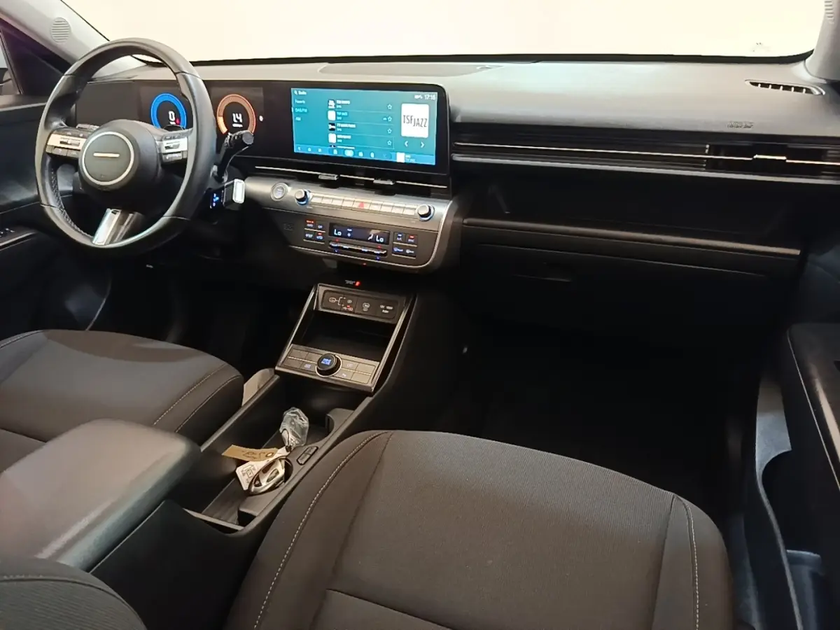 Intérieur avant du Hyundai Kona 2024, vue côté conducteur, tableau de bord noir avec écran tactile 12,3 pouces.