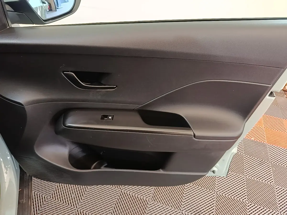 Gros plan sur la porte côté gauche du Hyundai Kona 2024 hybride, montrant la poignée et le panneau de commande noir.