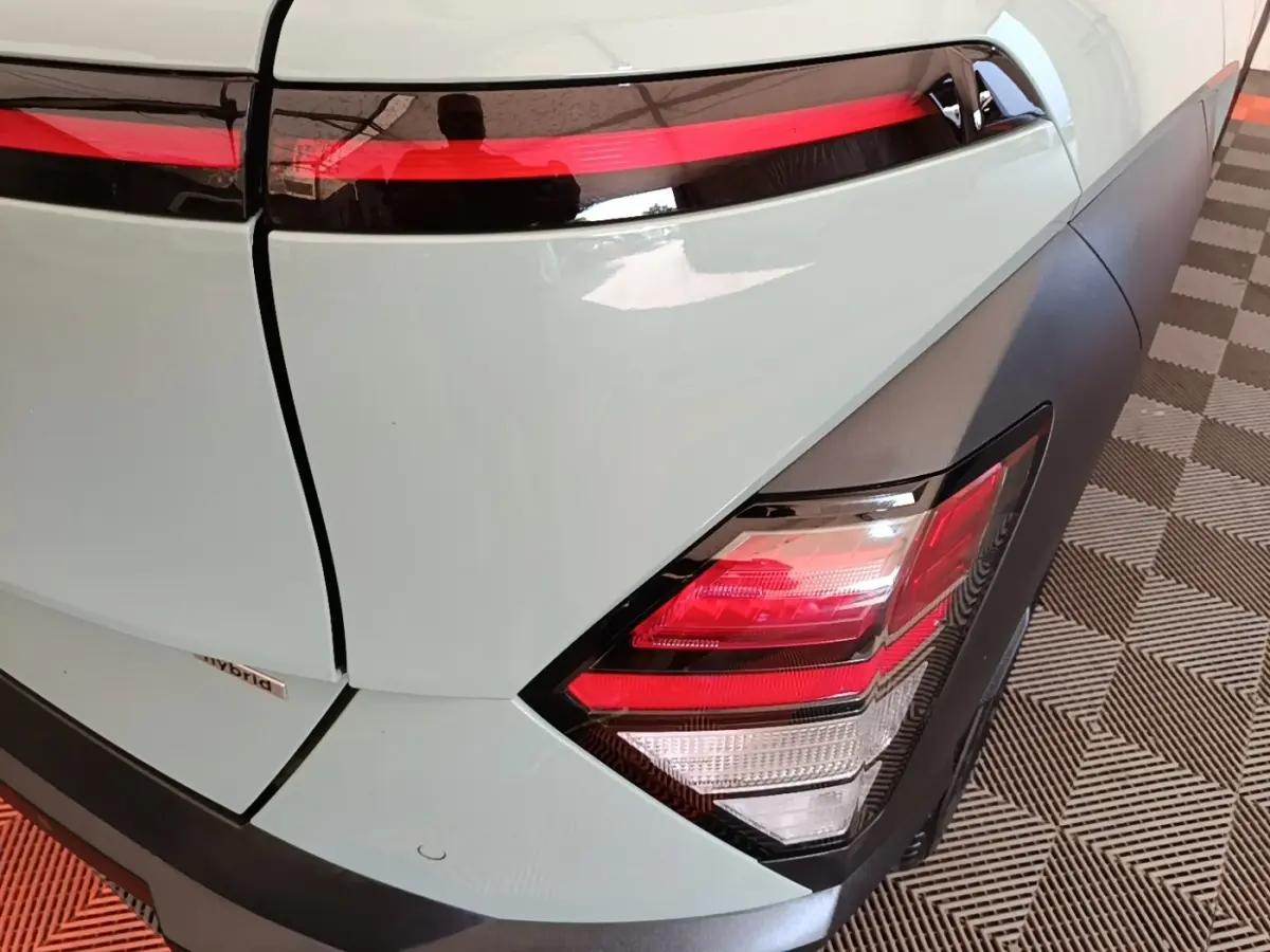 Gros plan sur le feu arrière droit et la partie arrière verte du Hyundai Kona 1.6 Hybrid 2024 avec bandeau lumineux rouge.