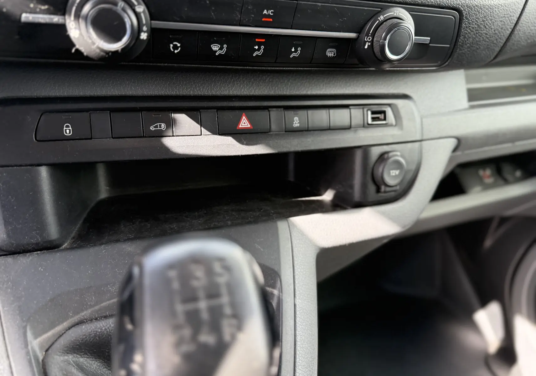 Gros plan sur la console centrale du Peugeot Expert FGN 2017, montrant la boîte manuelle et les commandes de climatisation.