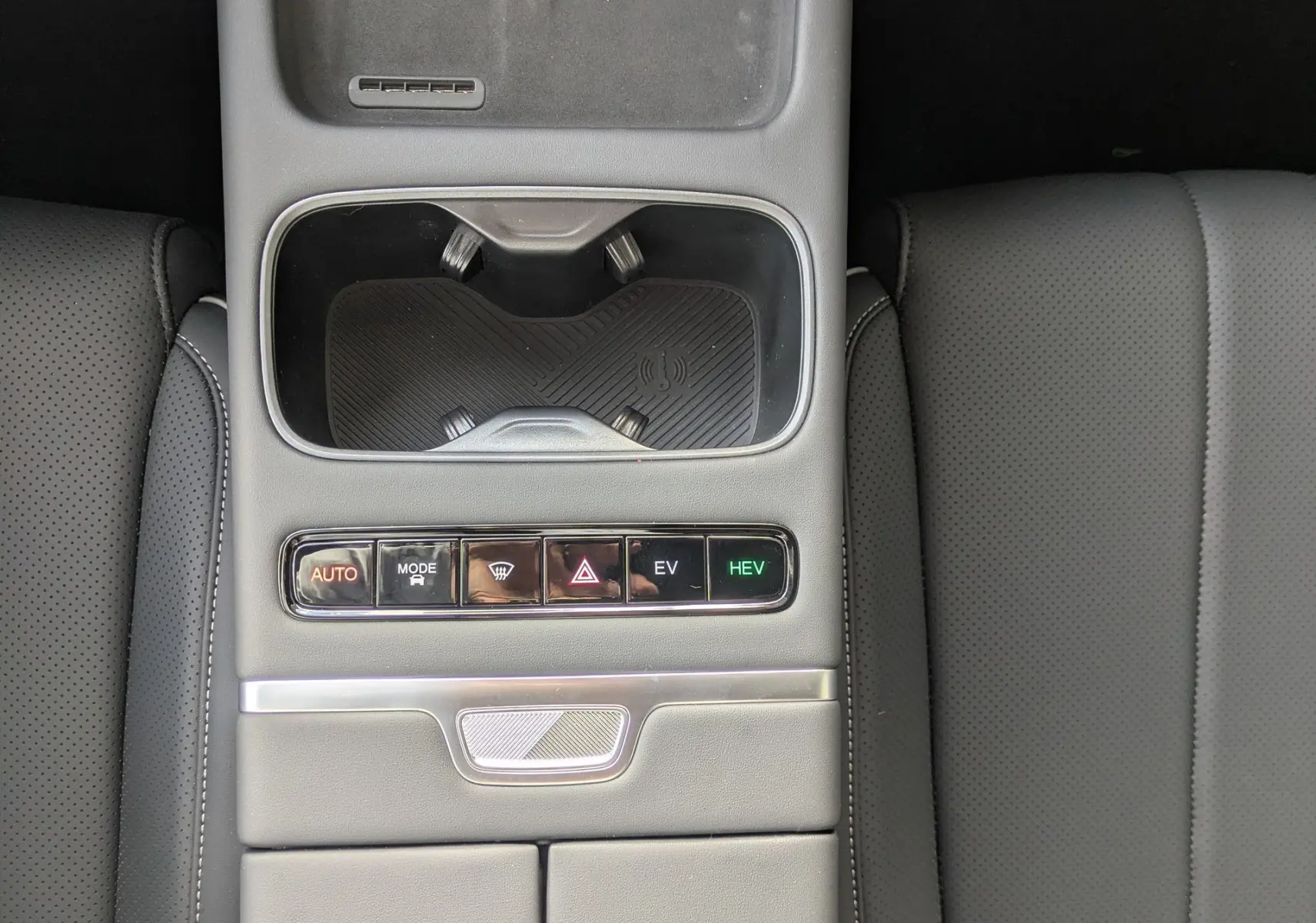 Vue plongeante sur la console centrale noire du JAECOO J7 2026, avec commandes EV, HEV et porte-gobelets.