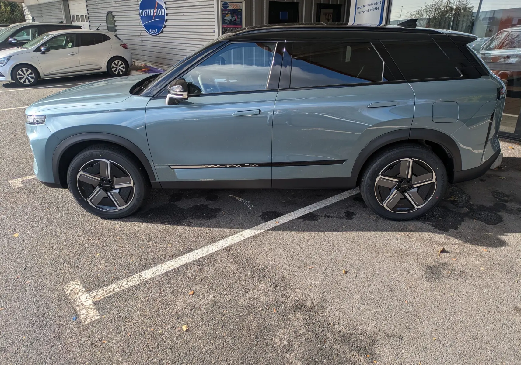 Vue de profil côté gauche du SUV JAECOO J7 hybride rechargeable en olive grey metal avec toit noir, roues modernes et lignes épurées.