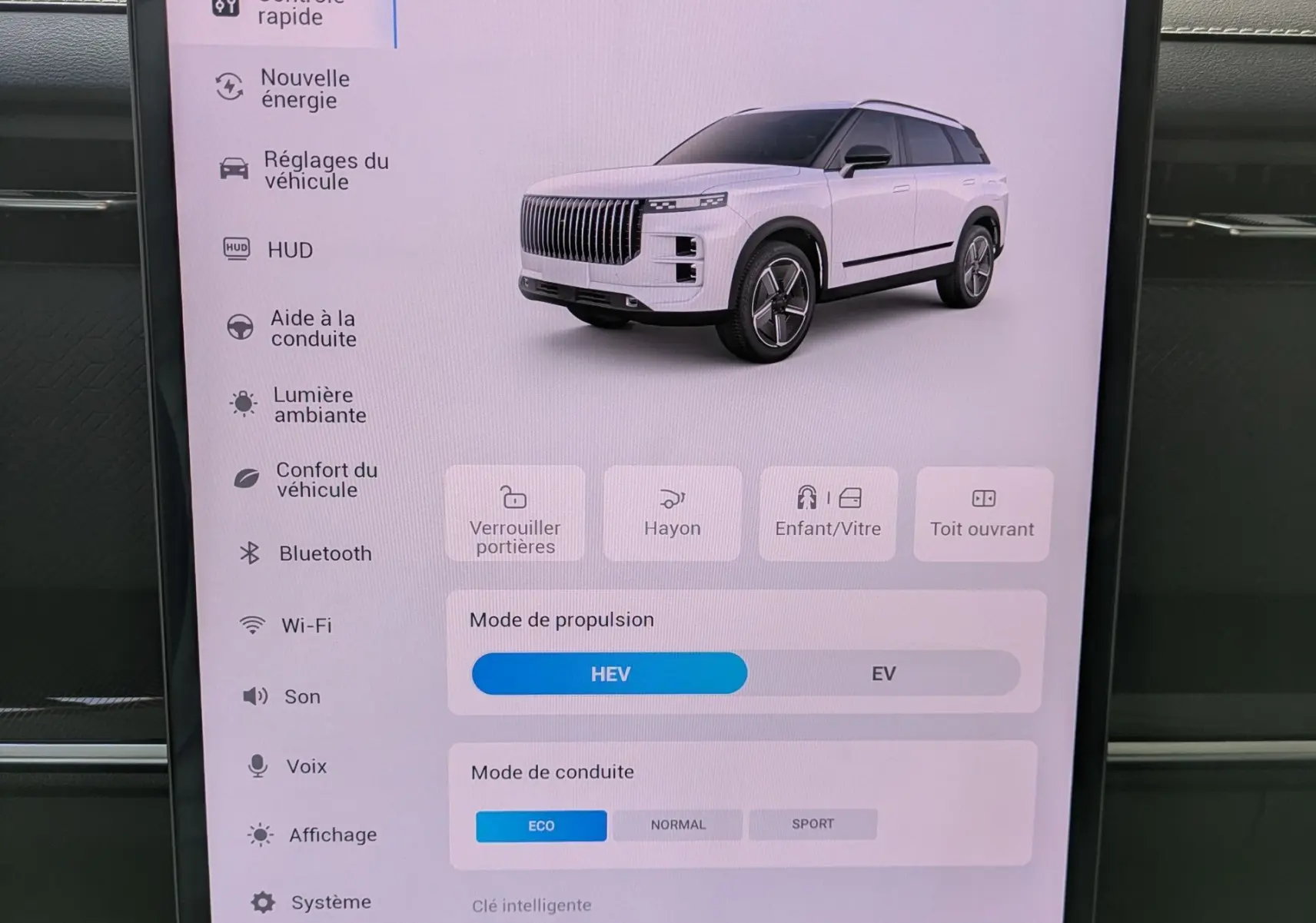 Écran tactile intérieur montrant les réglages du véhicule avec une image 3D du SUV JAECOO J7 en blanc, vue 3/4 avant.