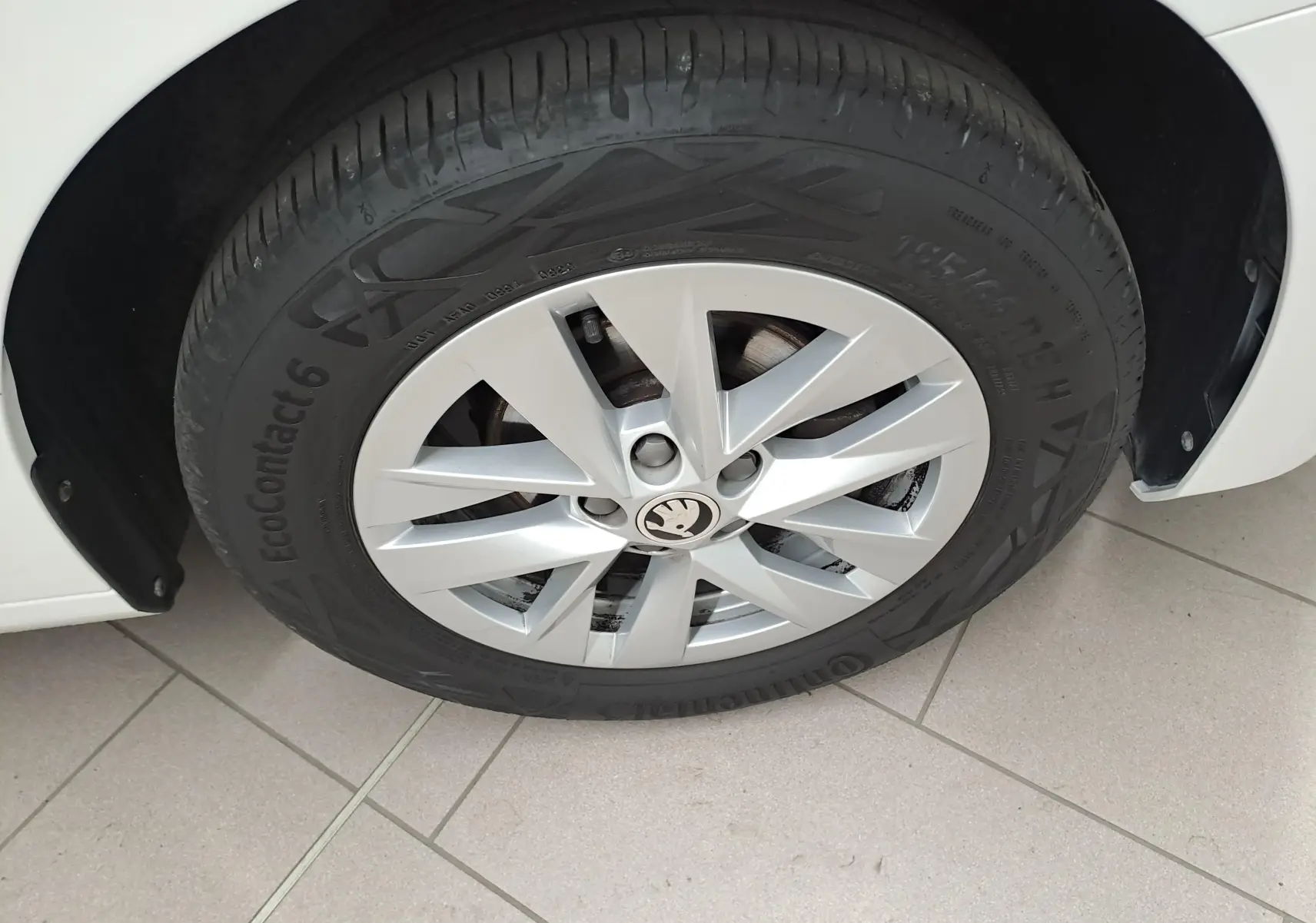 Gros plan sur la roue avant gauche d'une Skoda Fabia blanc candy 2023 avec jante alliage et pneu Continental EcoContact 6.
