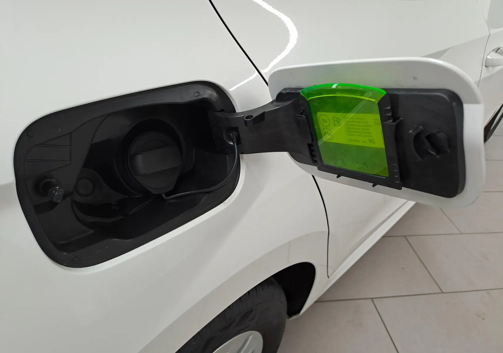 Ouverture de la trappe à carburant côté gauche sur une Skoda Fabia blanc candy 2023 essence.