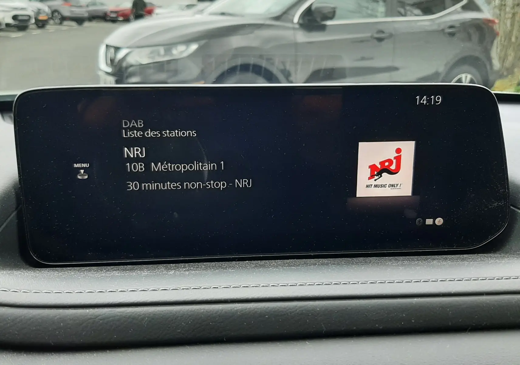Affichage de l'écran multimédia intérieur d'une Mazda CX-30 2024, vue de face avec radio NRJ en cours.
