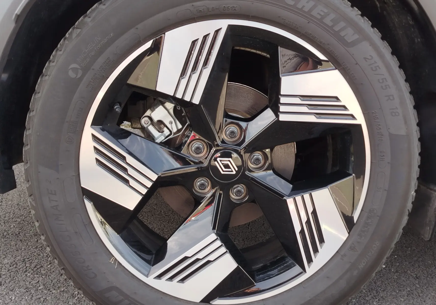 Gros plan sur la jante noire et argentée au design géométrique du Renault Symbioz 2025, avec logo central visible.