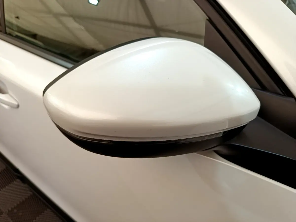 Gros plan sur le rétroviseur droit blanc d'un Peugeot 2008 1.5 BlueHDi 2021, avec clignotant intégré.