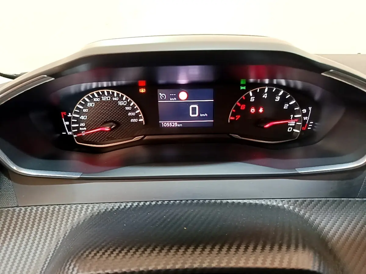 Vue rapprochée du tableau de bord numérique du Peugeot 2008 blanc, affichant 0 km/h et 105523 km au compteur.