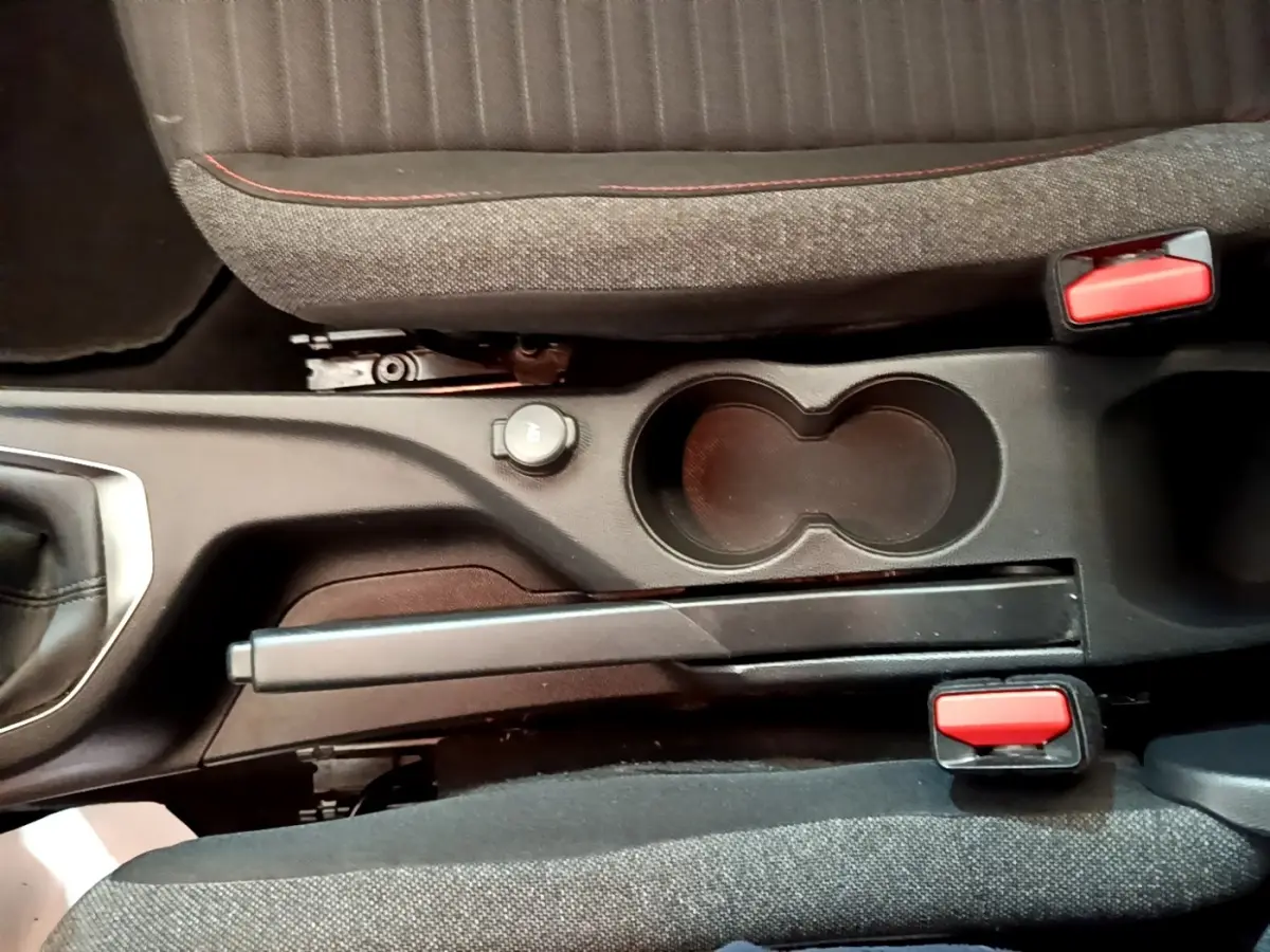 Vue rapprochée de la console centrale avec frein à main manuel et porte-gobelets du Peugeot 2008 blanc 2021.