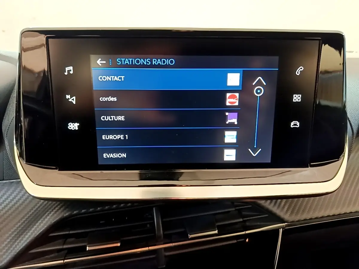 Écran tactile central affichant les stations radio dans l'habitacle du Peugeot 2008 blanc, version 2021.