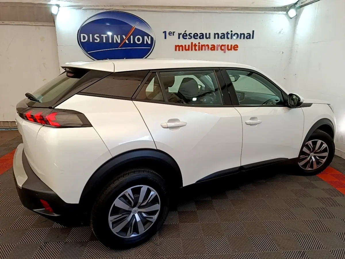 Peugeot 2008 blanc vue de profil côté droit, avec toit noir et feux arrière LED distinctifs.