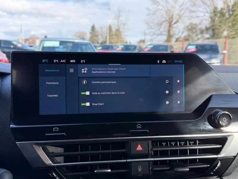 Écran tactile central du tableau de bord de la Citroën C4 2024, affichant les aides à la conduite et la climatisation.