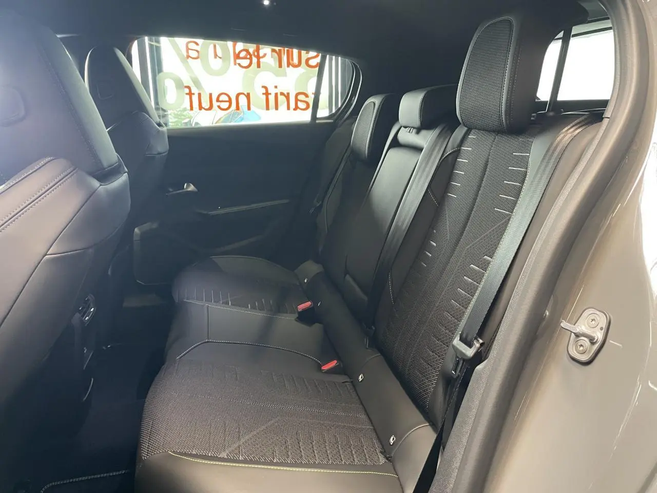 Vue côté droit de la banquette arrière noire avec surpiqûres vert Adamite dans une Peugeot 308 gris Selenium 2026.