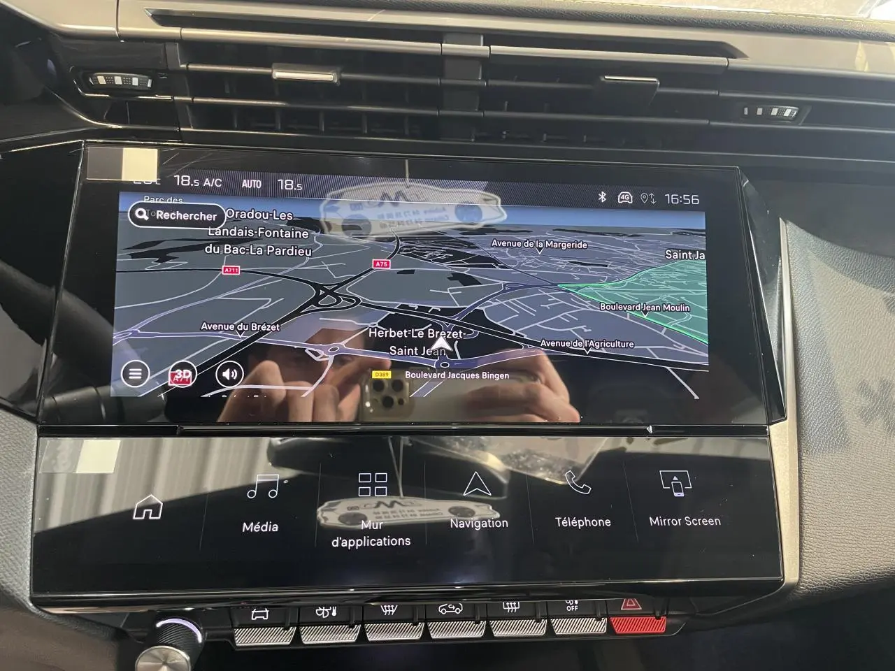 Vue rapprochée de l’écran tactile central du Peugeot 308 gris Selenium avec navigation 3D et commandes tactiles.