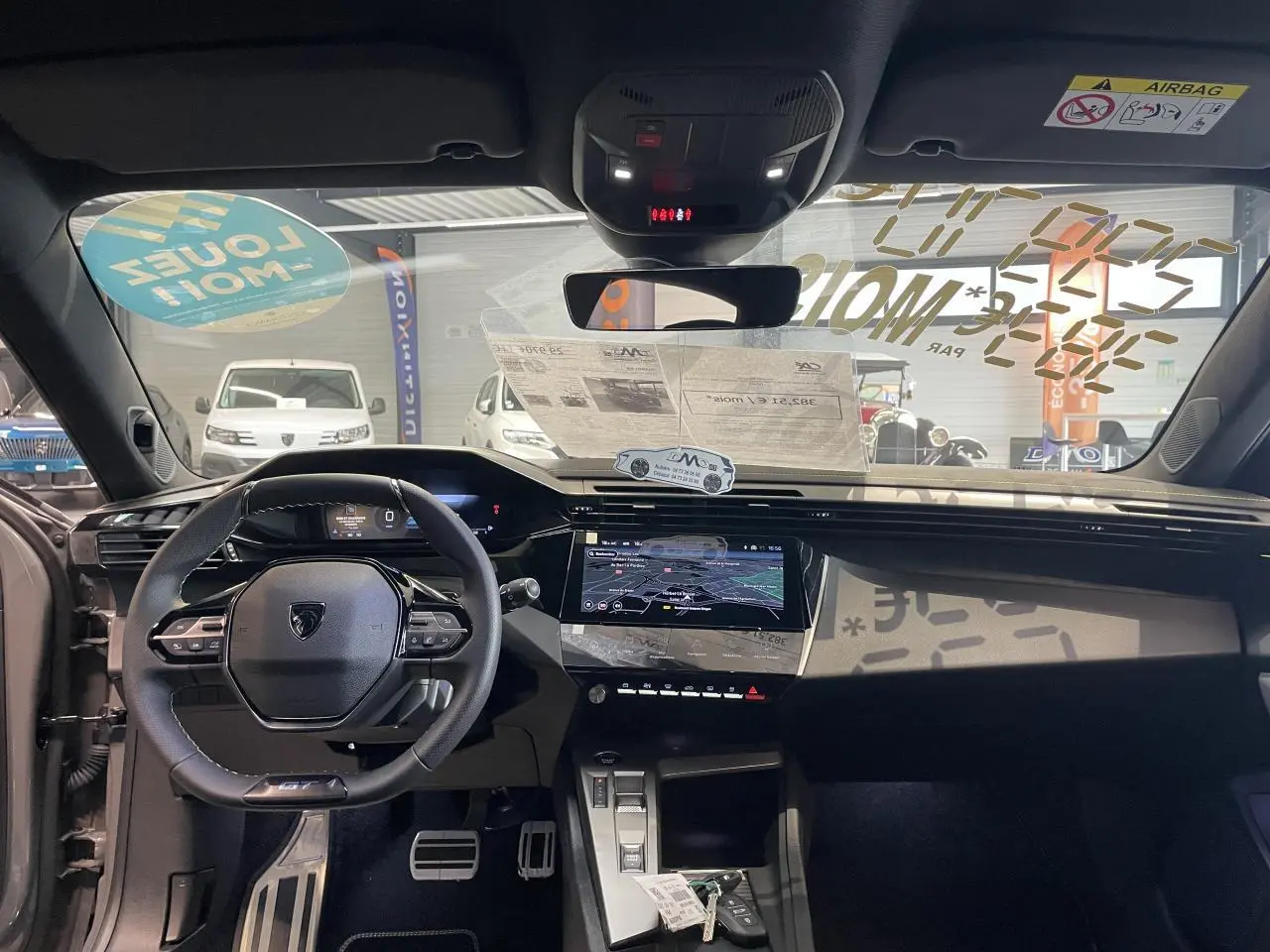 Vue intérieure avant de la Peugeot 308 gris selenium, avec volant compact GT, écran tactile et tableau de bord numérique.