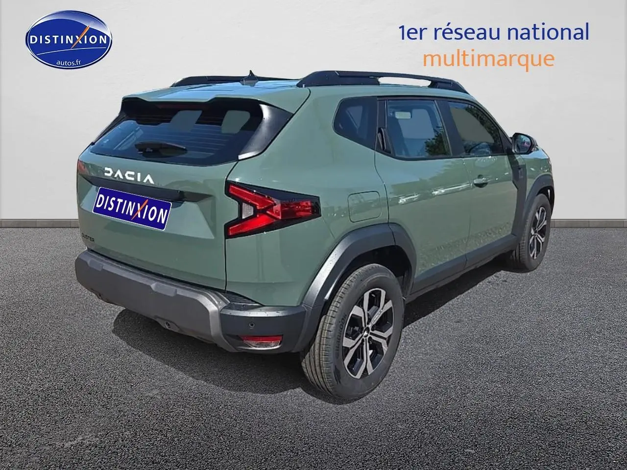 Vue 3/4 arrière droite d'un Dacia Duster vert kaki avec jantes alu et barres de toit noires.