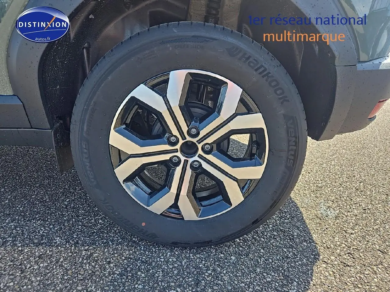 Gros plan sur la roue avant droite du Dacia Duster vert kaki avec jante alu au design moderne.