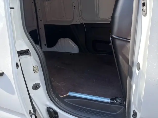 Vue intérieure de la zone de chargement arrière du Citroën Berlingo blanc, montrant le plancher bois et la cloison pleine.