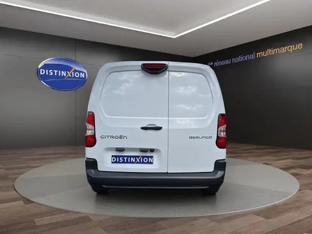 Vue arrière d'un utilitaire Citroën Berlingo blanc avec portes battantes, logo et plaque Distinxion visibles.