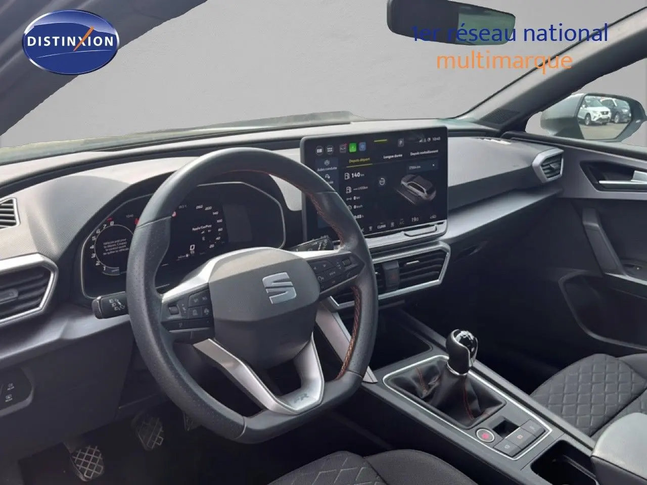 Intérieur de la SEAT LEON ST 1.5 eTSI 2025, vue du poste de conduite avec volant multifonction et écran tactile central.