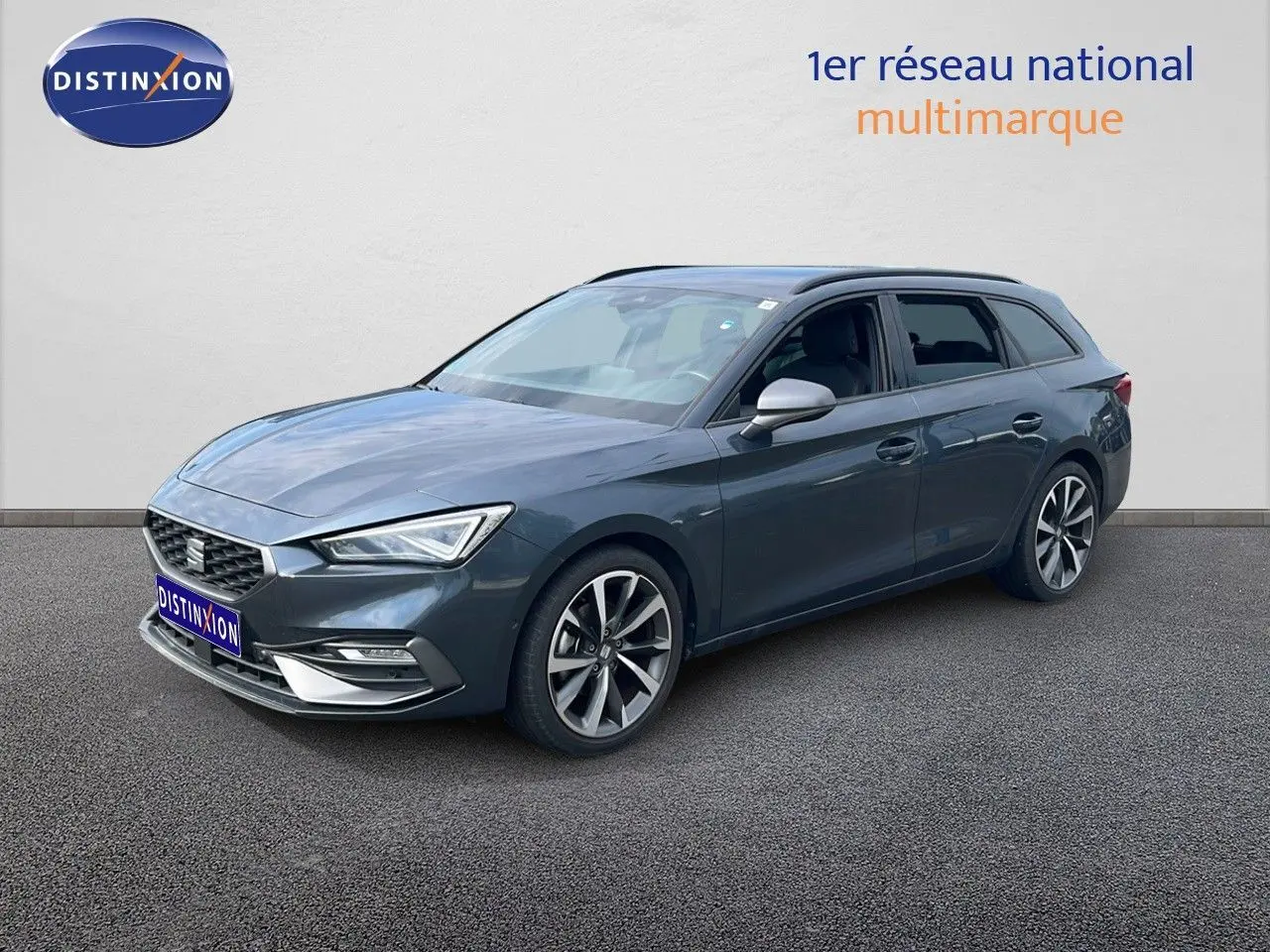 SEAT LEON ST gris magnétique métal en vue 3/4 avant droit, avec jantes alliage et lignes dynamiques.