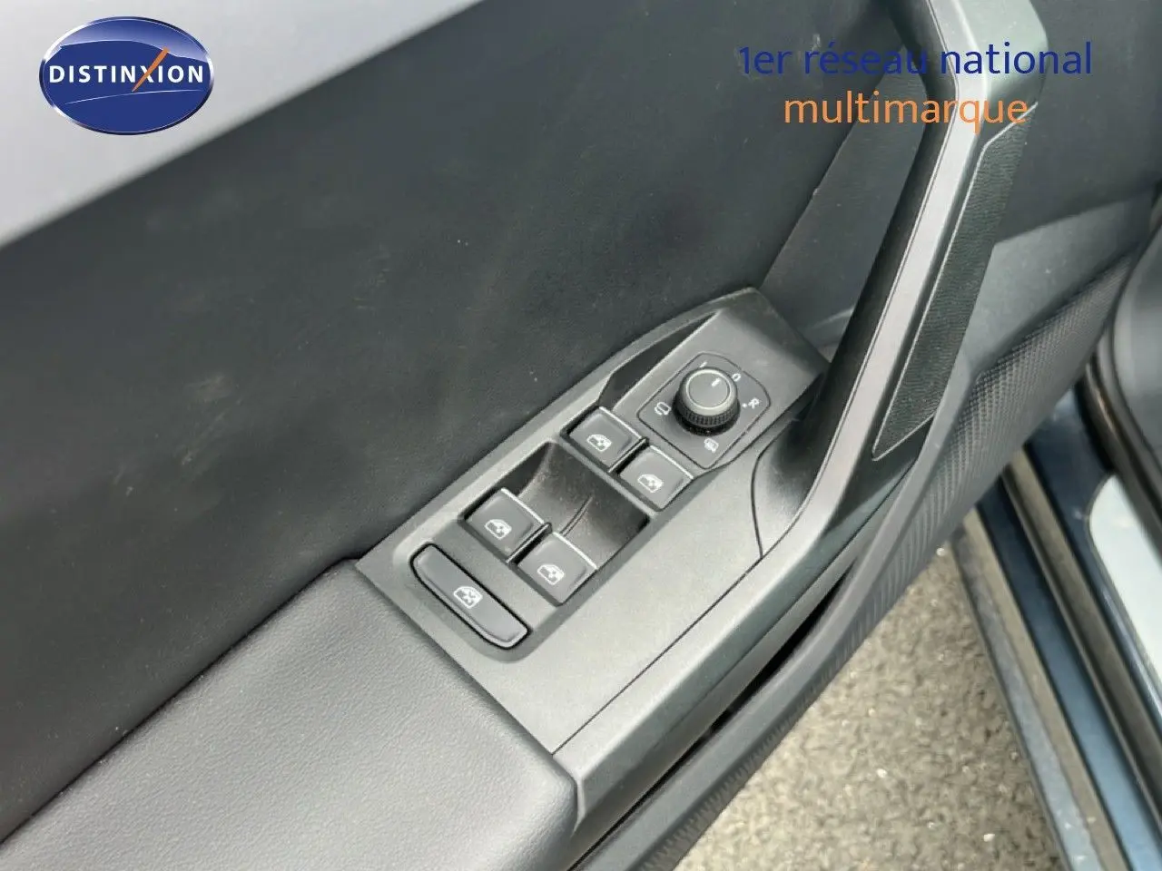 Gros plan sur la commande des vitres électriques côté conducteur d'une SEAT LEON ST gris magnétique 2025.