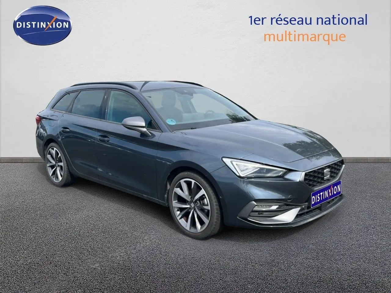 SEAT Leon ST gris magnétique métal vue 3/4 avant droit, avec jantes alliage et calandre hexagonale distinctive.