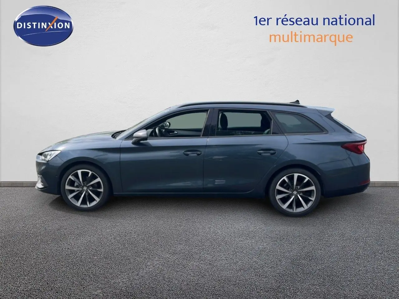 Vue de profil côté gauche d'une SEAT LEON ST gris magnétique métallisé avec jantes alliage et toit panoramique.